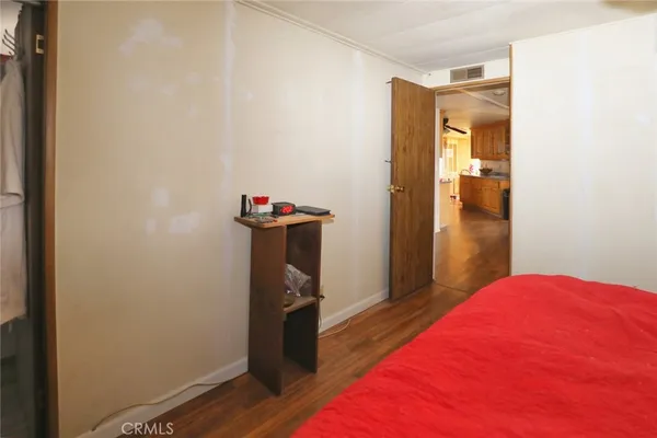 a room with a bed and wooden floor