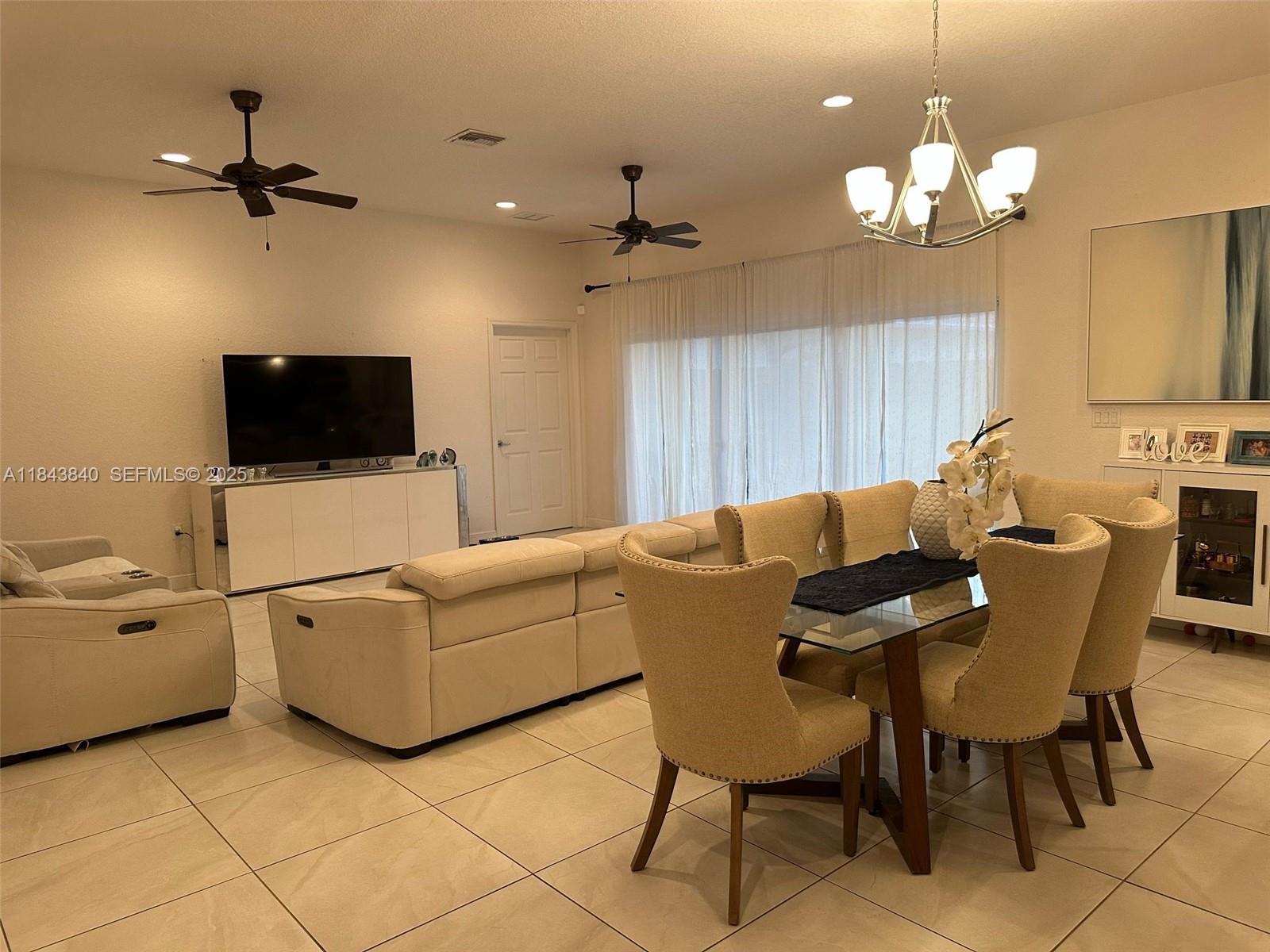 210 Southwest 4th Street, Unit 210 Dania Beach, FL 33004 - Photo 12 of 22 a living room with furniture a chandelier and a flat screen tv