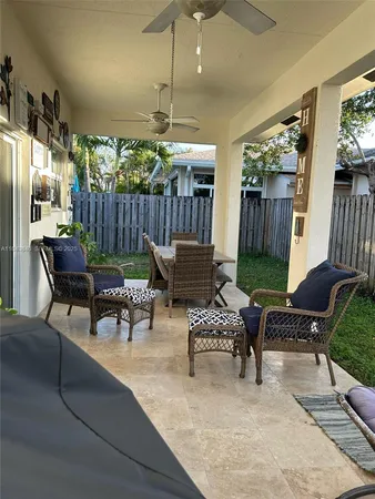 a outdoor living space with furniture potted plant and a large window