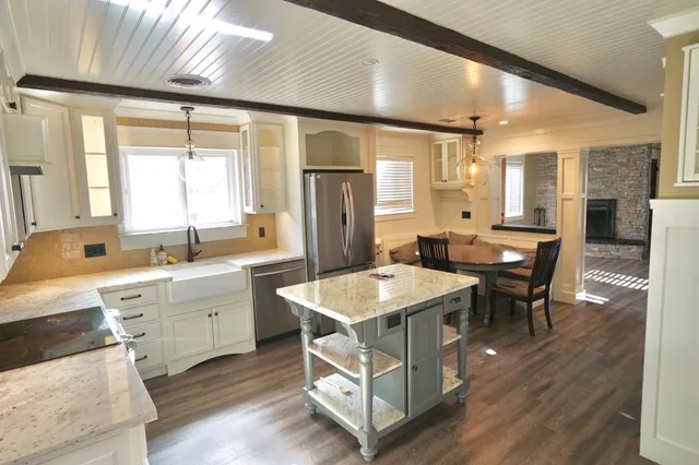 a kitchen with a refrigerator a stove and a wooden floor