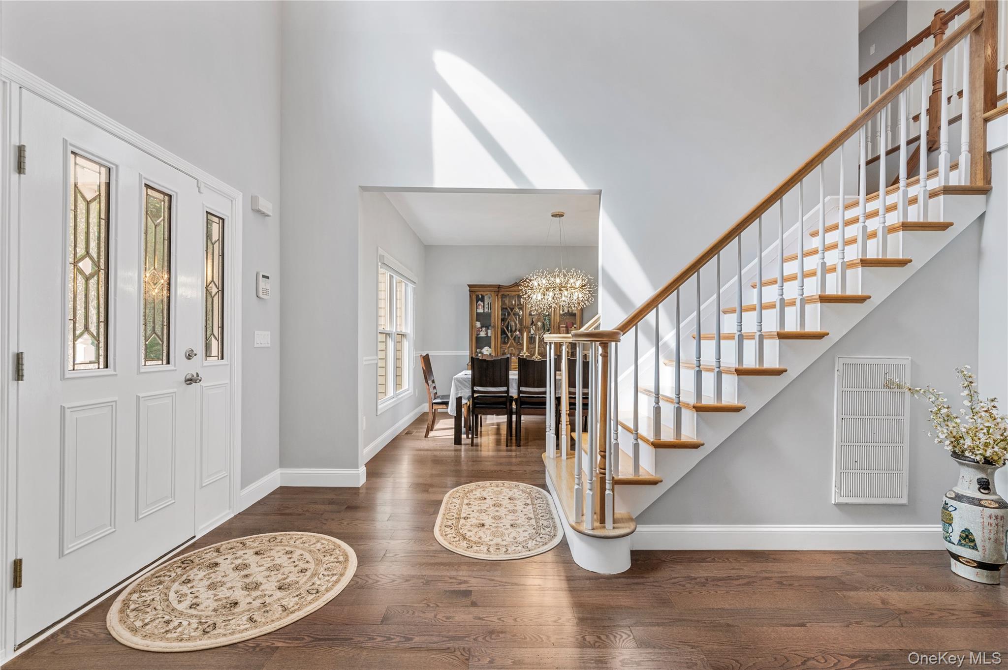 91 Bennetts Road East Setauket, NY 11733 - Photo 13 of 31 Foyer entrance with a chandelier, stairway, wood finished floors, and a high ceiling