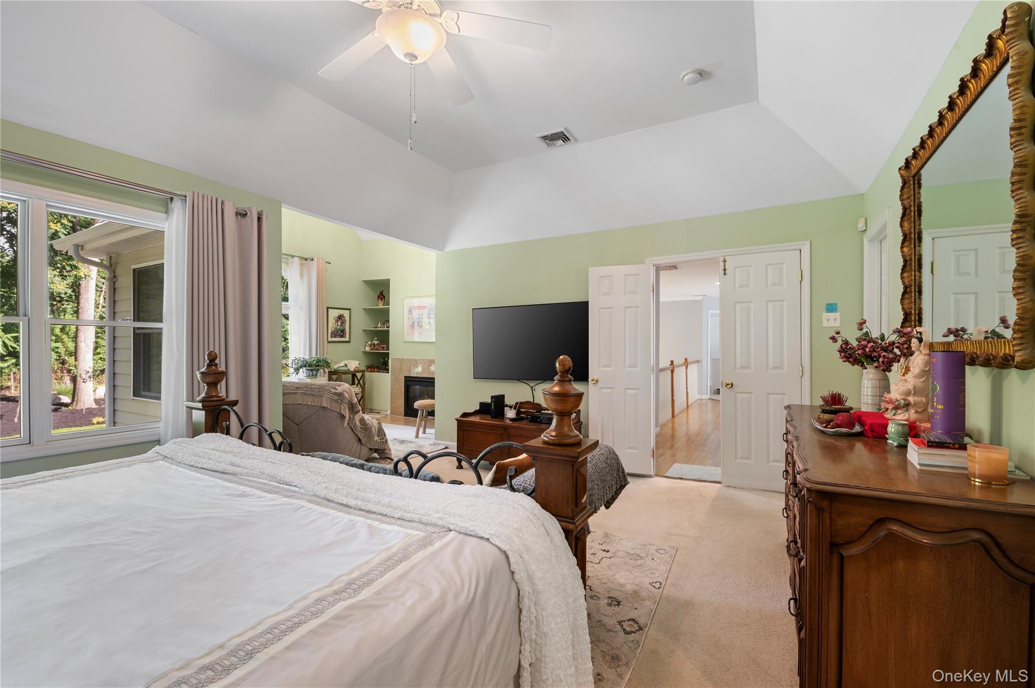 91 Bennetts Road East Setauket, NY 11733 - Photo 16 of 31 Master Bedroom featuring vaulted ceiling, light carpet, and ceiling fan, sitting area and fireplace.