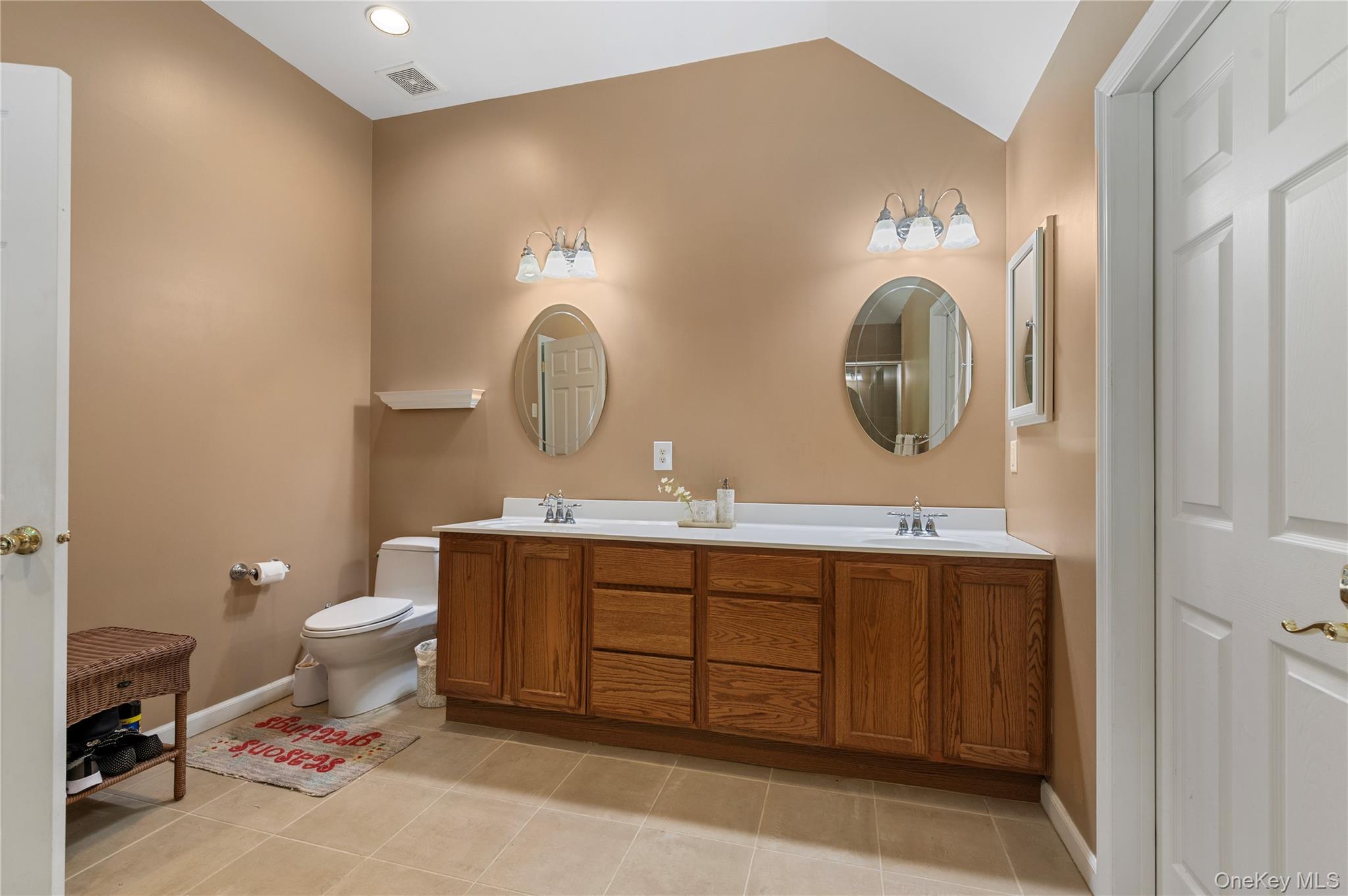 91 Bennetts Road East Setauket, NY 11733 - Photo 23 of 31 Bathroom featuring double vanity, tile patterned floors, and lofted ceiling
