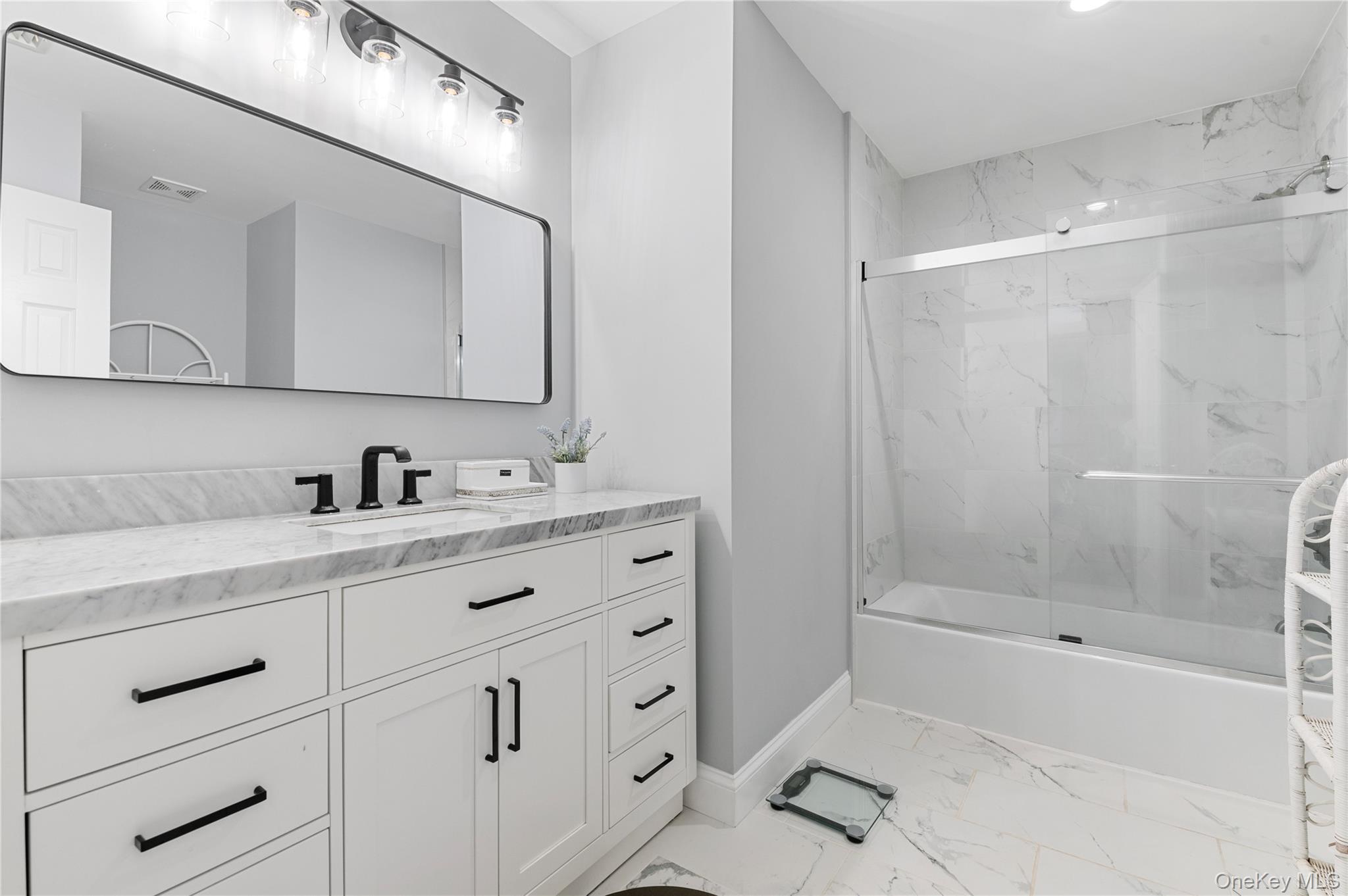 91 Bennetts Road East Setauket, NY 11733 - Photo 24 of 31 Bathroom featuring marble finish flooring, vanity, and combined bath / shower with glass door