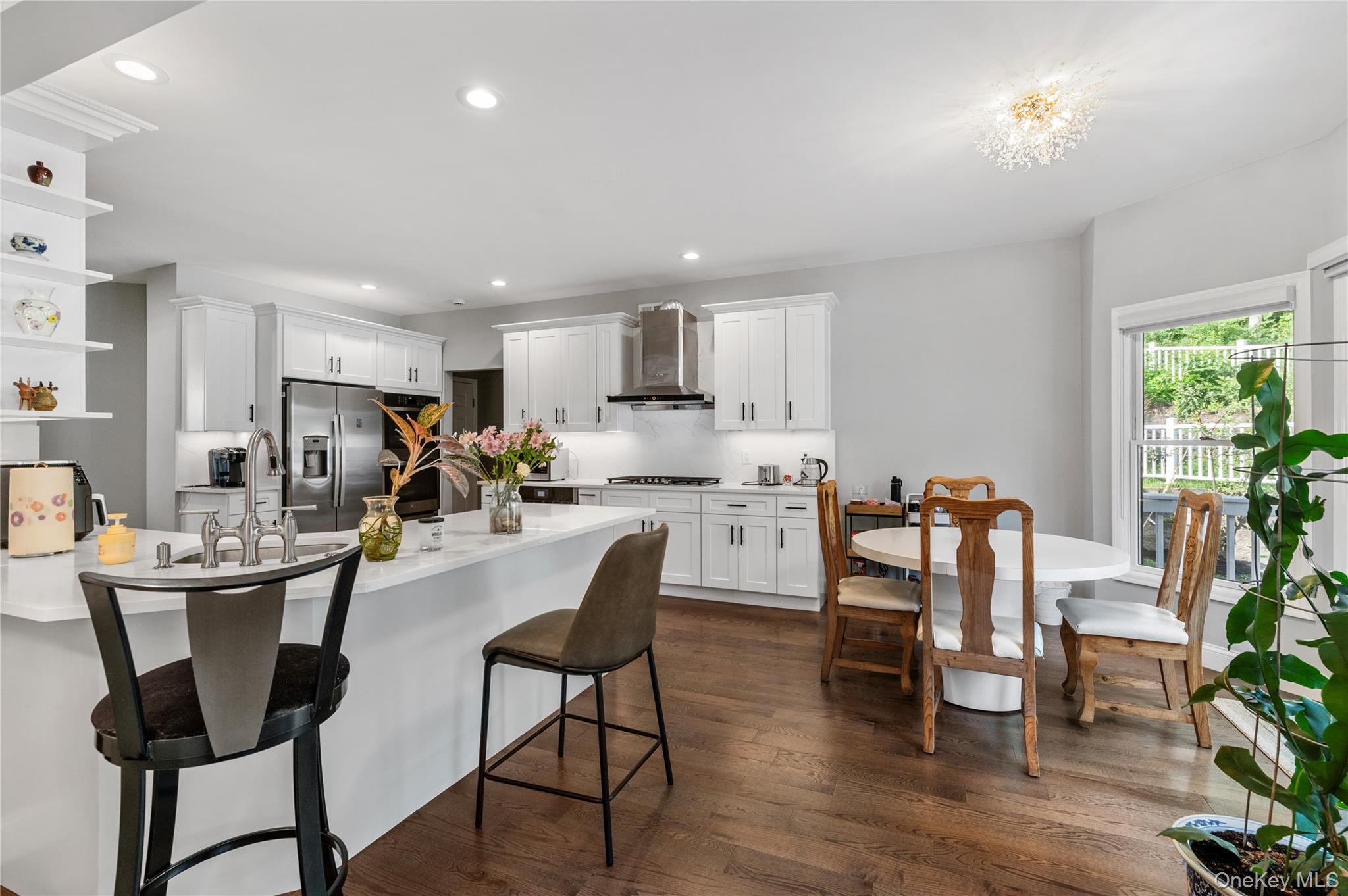 91 Bennetts Road East Setauket, NY 11733 - Photo 9 of 31 Kitchen featuring wall chimney exhaust hood, a breakfast bar area, stainless steel fridge, open shelves, and light countertops