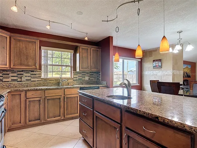a kitchen with stainless steel appliances granite countertop a sink a stove and a refrigerator