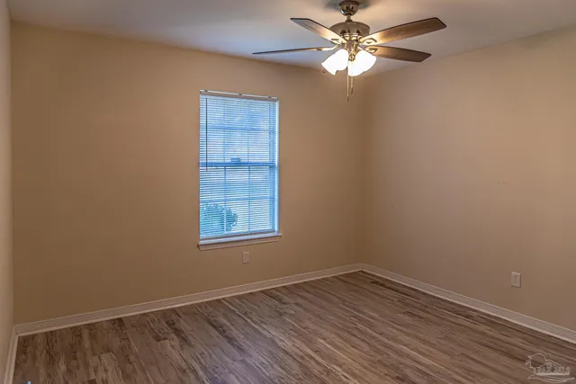 an empty room with a window and a fan