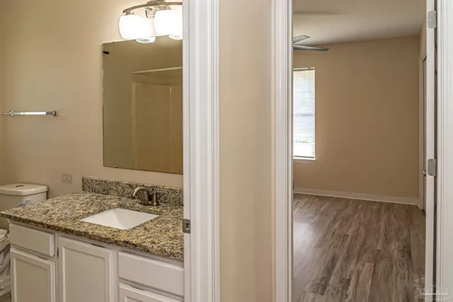 a bathroom with a granite countertop sink and a mirror