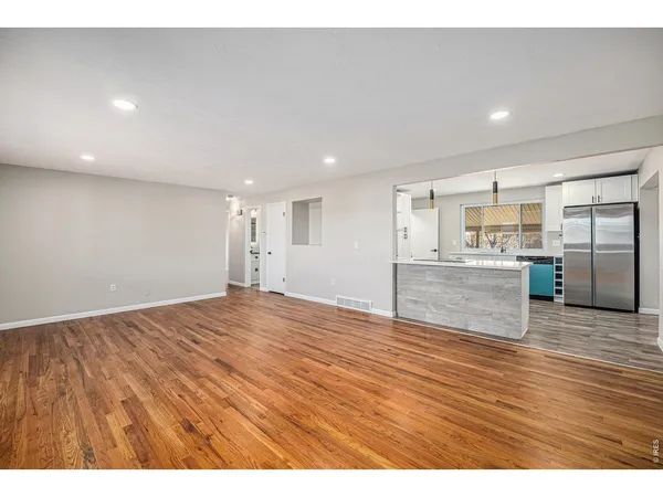 a view of empty room with wooden floor