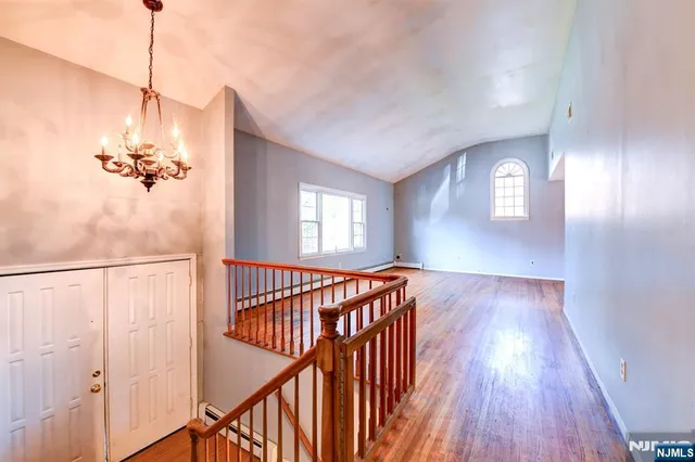 a view of a hallway with wooden floor and stairs