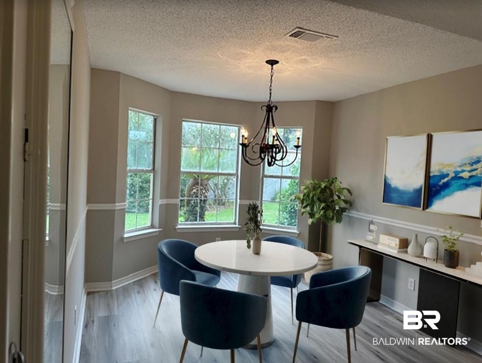 1512 North Cedar Street Foley, AL 36535 - Photo 4 of 13 Dining space featuring a textured ceiling, a notable chandelier, and light wood-type flooring