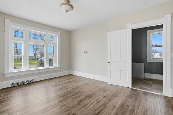 a view of a hallway with entryway and wooden floor