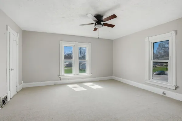 a view of an empty room with a ceiling fan