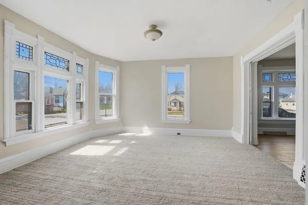 a view of an empty room with wooden floor and closet