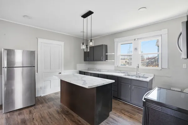 a kitchen with stainless steel appliances granite countertop a sink a stove and a refrigerator