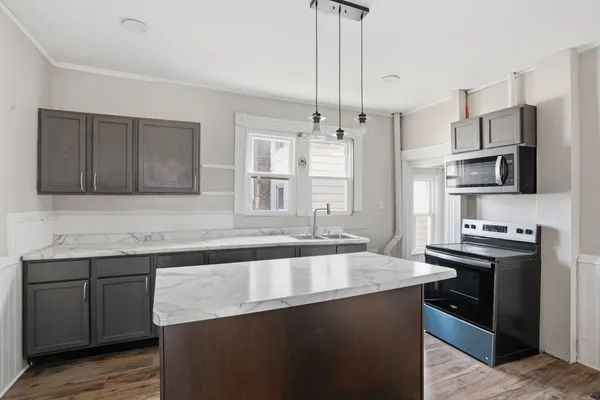a kitchen with stainless steel appliances granite countertop a sink stove and refrigerator
