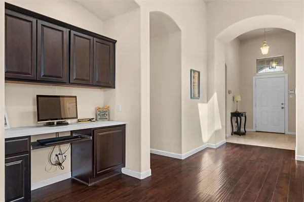 a kitchen with stainless steel appliances granite countertop a stove top oven a refrigerator and a microwave with wooden floors