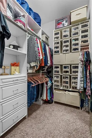 a view of walk in closet with clothes and shoes