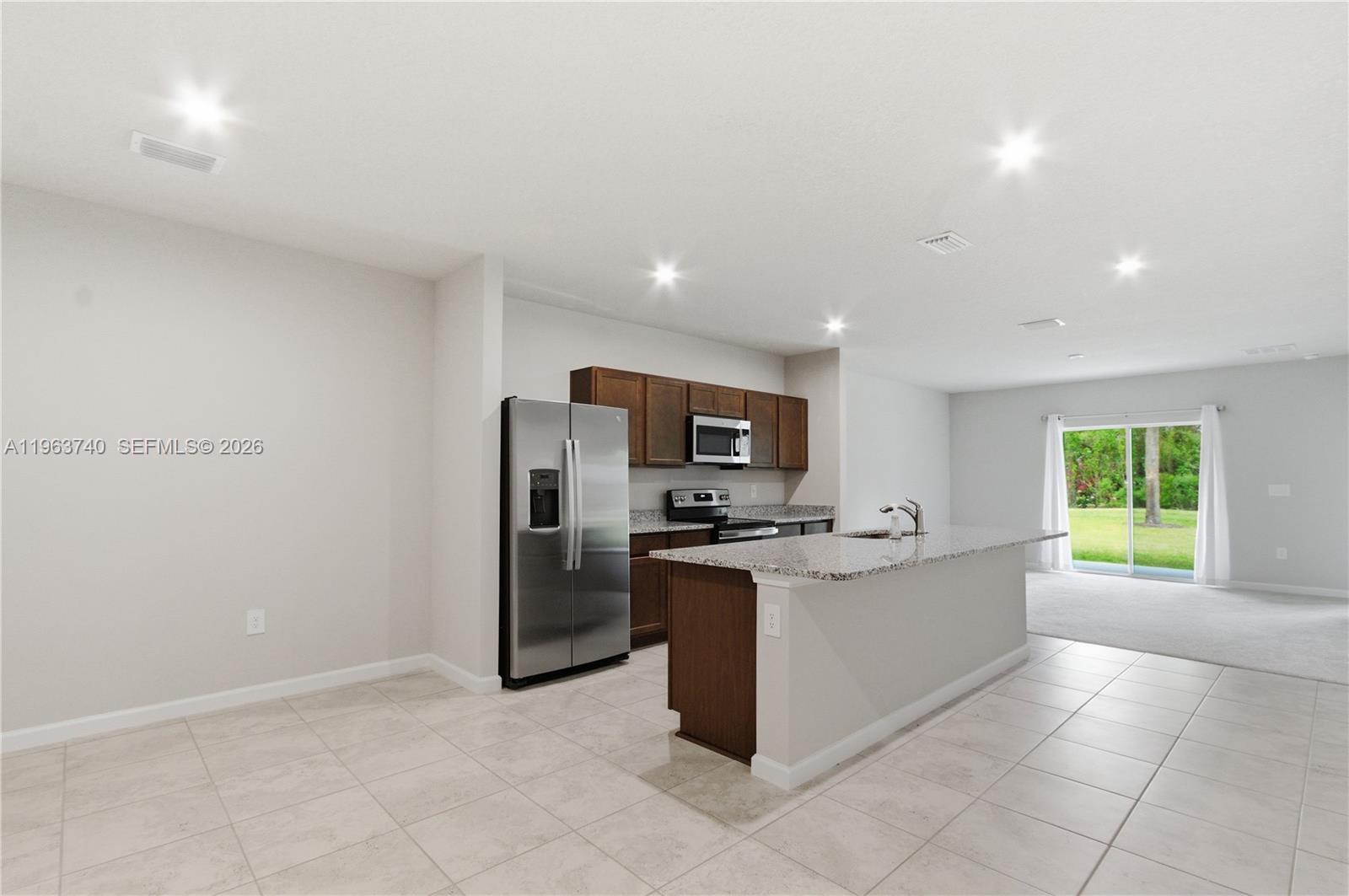 323 Raspberry Road, Unit 323 Fort Pierce, FL 34981 - Photo 5 of 29 a kitchen with stainless steel appliances granite countertop a refrigerator and a stove