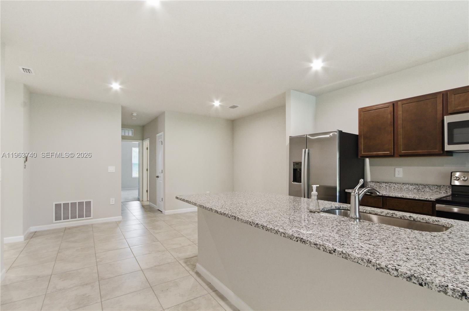 323 Raspberry Road, Unit 323 Fort Pierce, FL 34981 - Photo 7 of 29 a view of a kitchen with a sink and a refrigerator