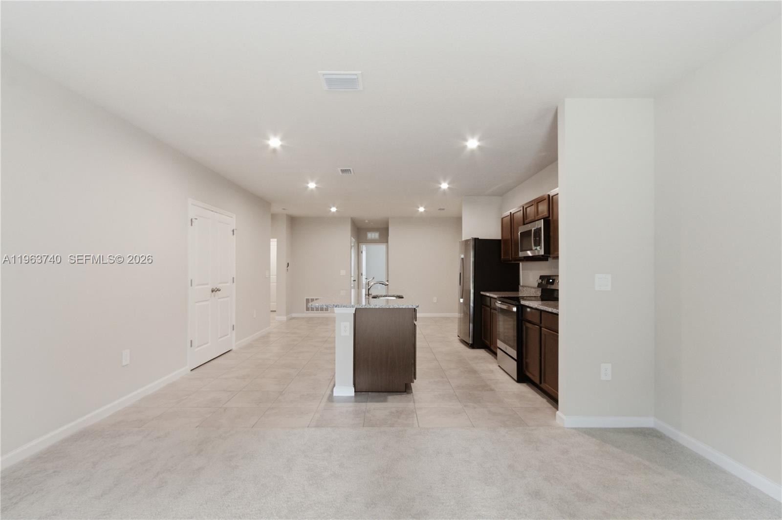 323 Raspberry Road, Unit 323 Fort Pierce, FL 34981 - Photo 8 of 29 a view of a kitchen with refrigerator and chairs