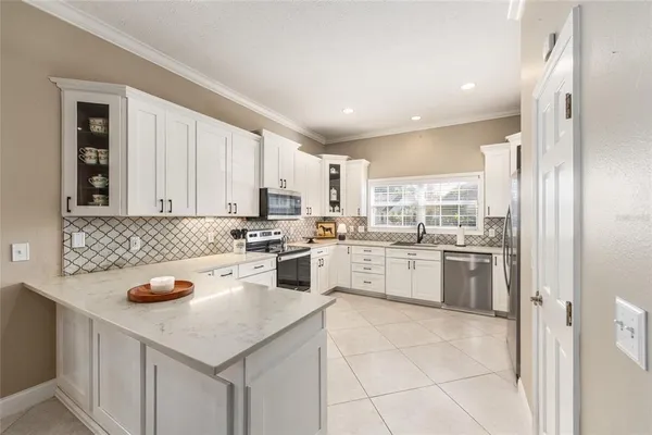 a kitchen with white cabinets stainless steel appliances and a window