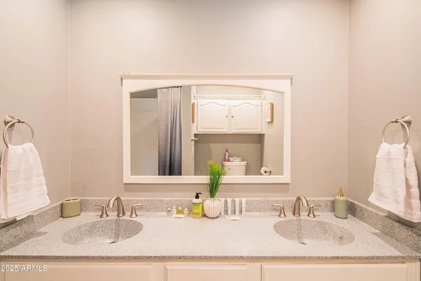 a bedroom with a white bed and a chandelier