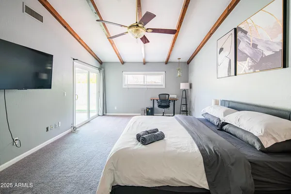 a bedroom with a bed and a flat screen tv