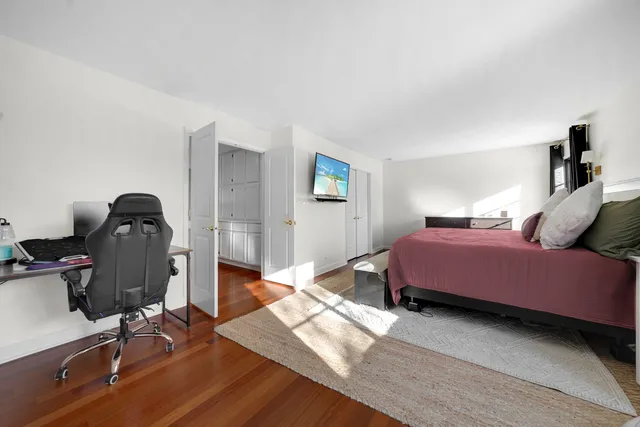 a bedroom with a bed and wooden floor