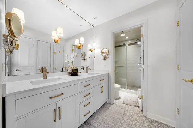 a bathroom with a double vanity sink a mirror and a shower