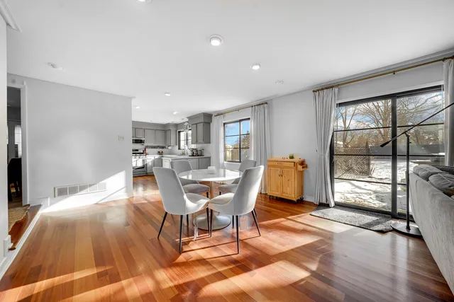 a living room with furniture a large window and wooden floor