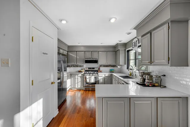 a kitchen with stainless steel appliances a sink a stove a refrigerator cabinets and a counter top space