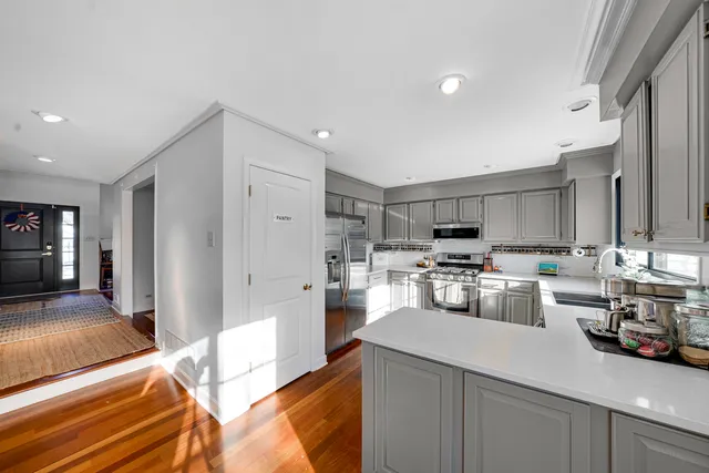 a view of kitchen with kitchen island stainless steel appliances refrigerator stove microwave and cabinets