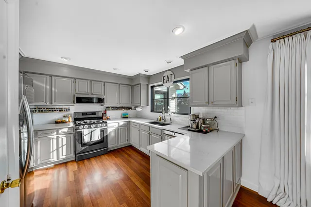 a kitchen with stainless steel appliances kitchen island granite countertop a sink stove and refrigerator