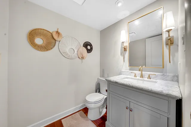 a bathroom with a granite countertop sink mirror vanity and toilet