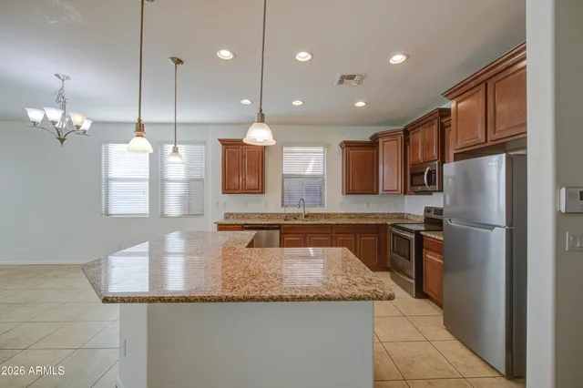 a kitchen with stainless steel appliances granite countertop a sink a stove a microwave and island