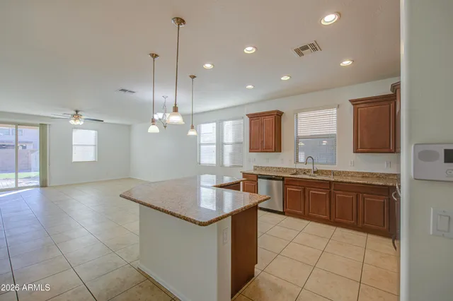 a kitchen with kitchen island granite countertop a sink a counter top space appliances and cabinets