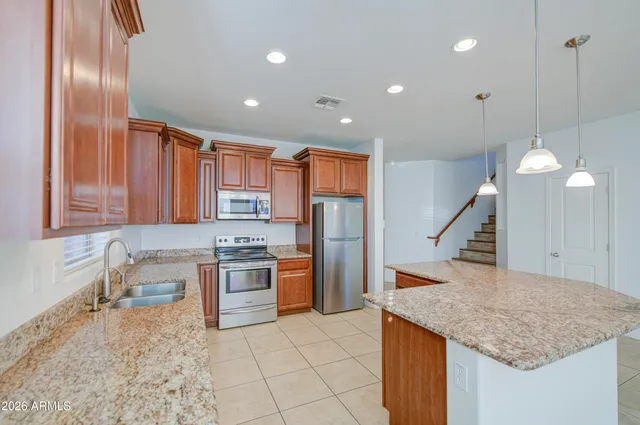 a kitchen with stainless steel appliances granite countertop a sink a stove and a refrigerator