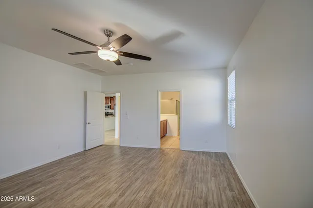 a view of a livingroom with wooden floor and a ceiling fan