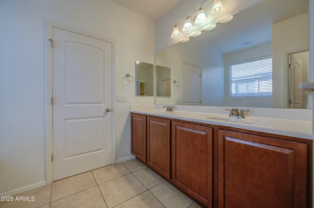 a bathroom with a double vanity sink a mirror and a bathtub