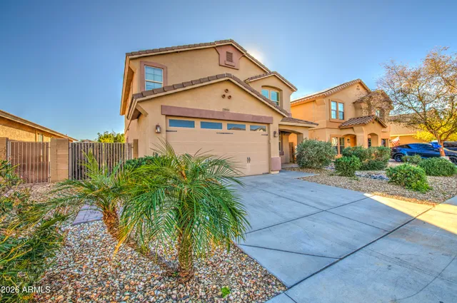 a front view of a house with a yard and potted plants