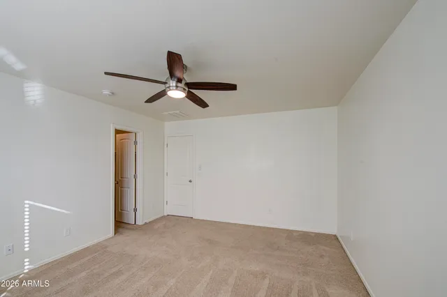 a living room with a ceiling fan and a window