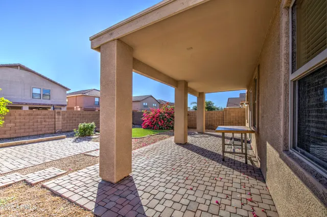a patio with glass top table and chairs