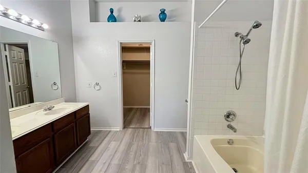 a bathroom with a tub sink and mirror