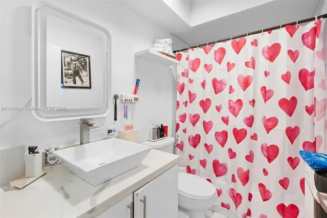 a bathroom with a sink toilet and a mirror