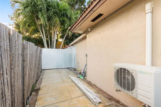a view of a backyard with wooden fence and large trees