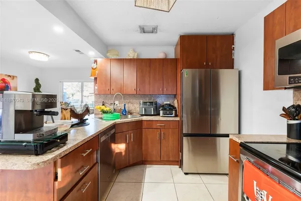 a kitchen with stainless steel appliances granite countertop a refrigerator stove a sink dishwasher and microwave