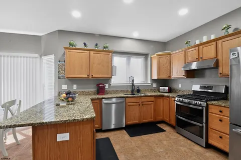 a kitchen with stainless steel appliances granite countertop a sink stove and refrigerator