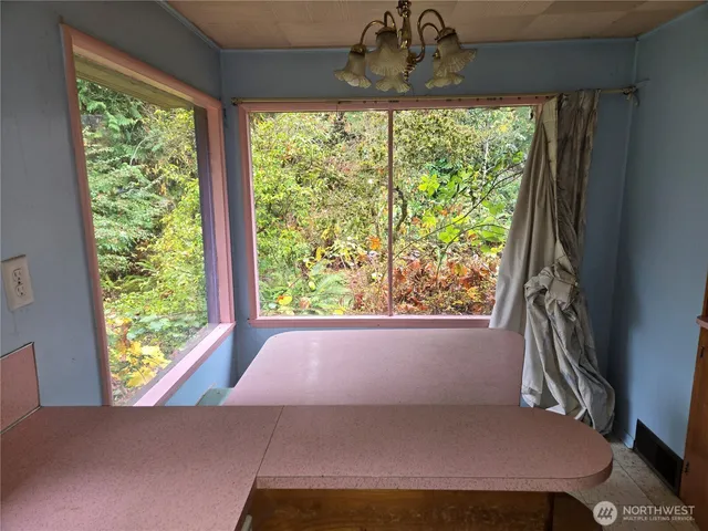 a view of a hallway with furniture and a window