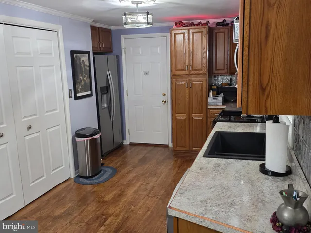 view of a utility room with closet and wooden floor